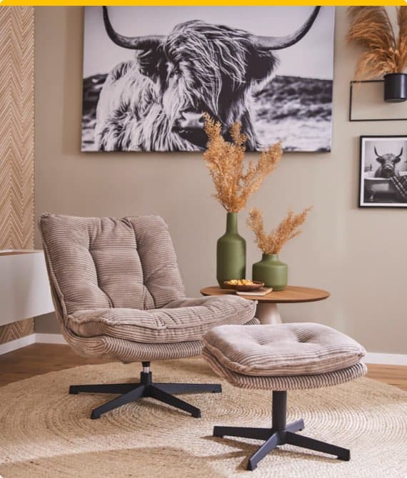 Sessel mit Fußhocker auf Teppich, Tisch mit grünen Vasen und Trockenblumen, Wandbilder mit Hochlandrind-Motiven im Wohnzimmer