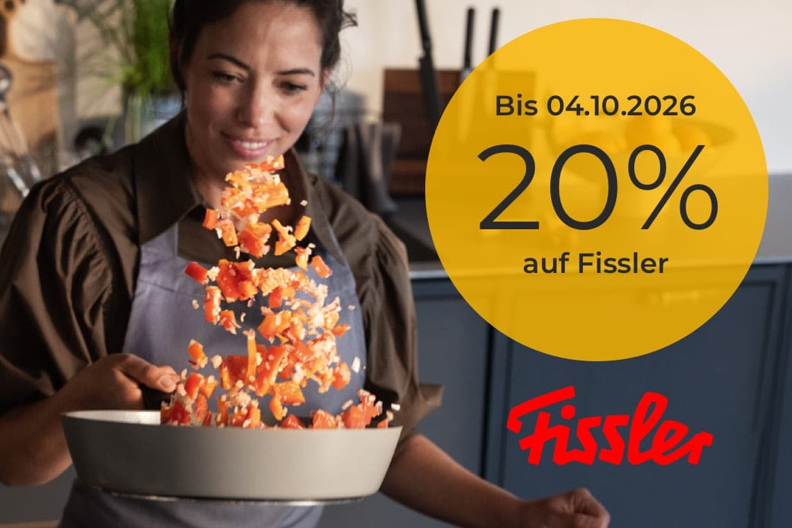 Bis 04.10.2026 20 % auf Fissler – Person schwenkt Pfanne, Gemüsewürfel fliegen in der Küche hoch