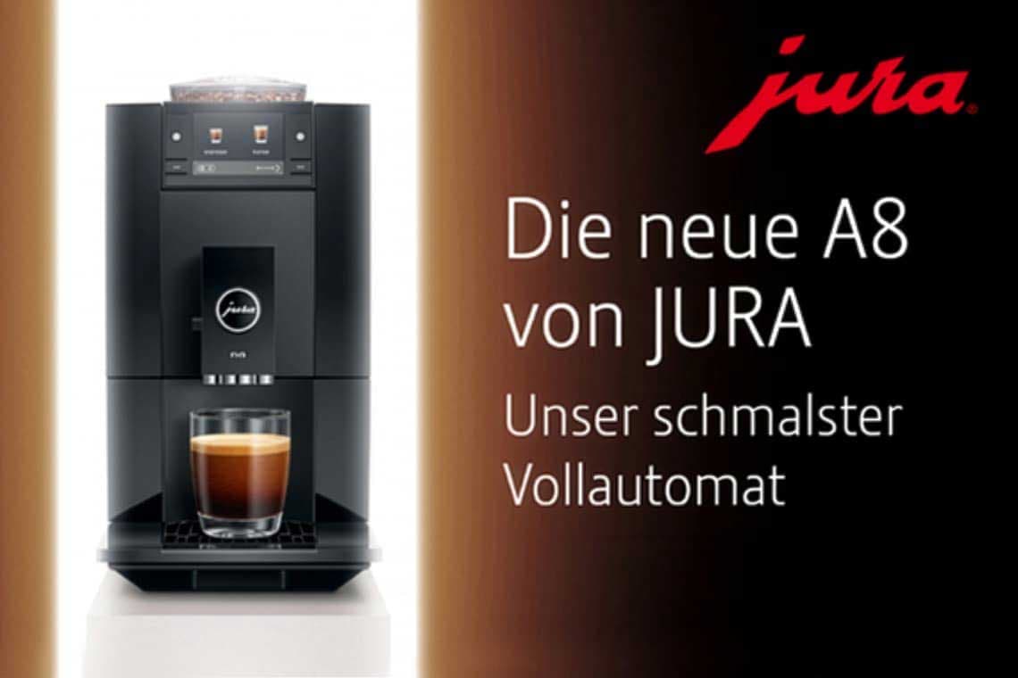 Die neue A8 von JURA – unser schmalster Vollautomat, daneben Maschine mit Glas Kaffee auf hellem Sockel