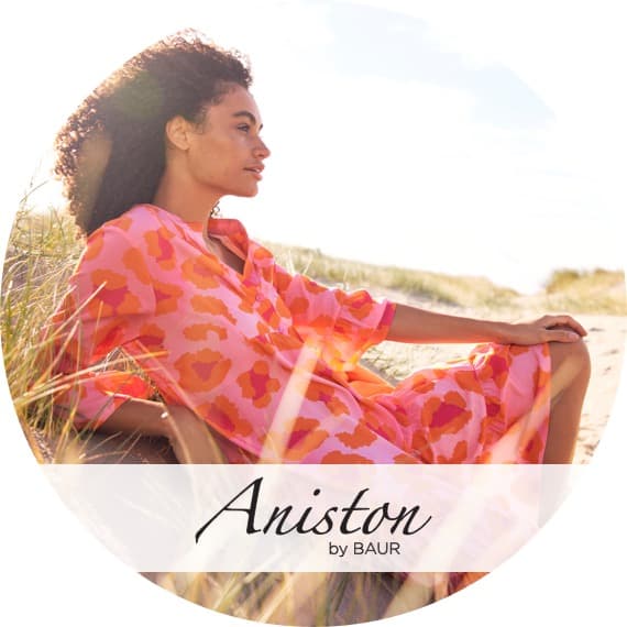 Aniston – Frau liegt mit rotgemusterter Tunika am Strand