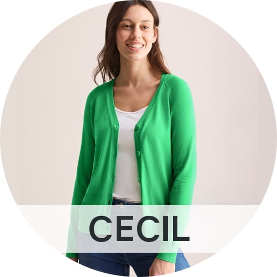 Cecil – Frau mit langen Haaren trägt ein weißes T-Shirt mit grüner Jacke