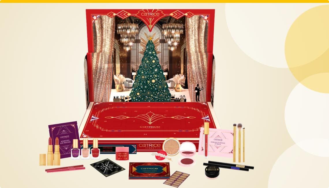 Catrice Adventskalender mit festlich geschmücktem Weihnachtsbaum und verschiedenen Make-up-Produkten davor