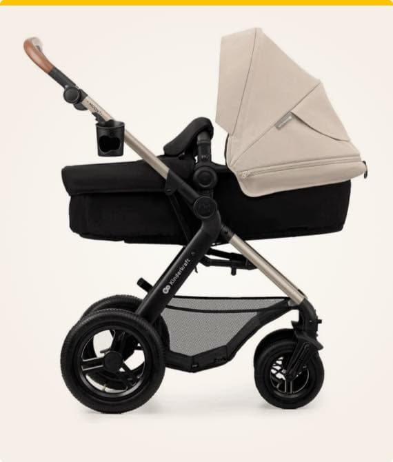 Kinderwagen mit schwarzem Rahmen und beiger Babywanne, Becherhalter am Griff befestigt