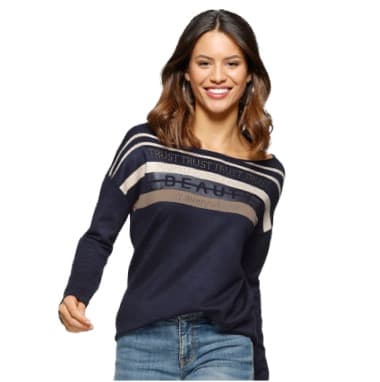 Frau in dunkelblauem Pullover mit Streifen und Schriftzug, trägt blaue Jeans.