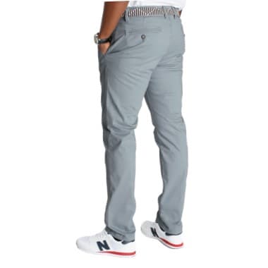 Mann in grauer Hose und weißen Sneakern steht mit Händen in den Hosentaschen, Rücken zur Kamera.