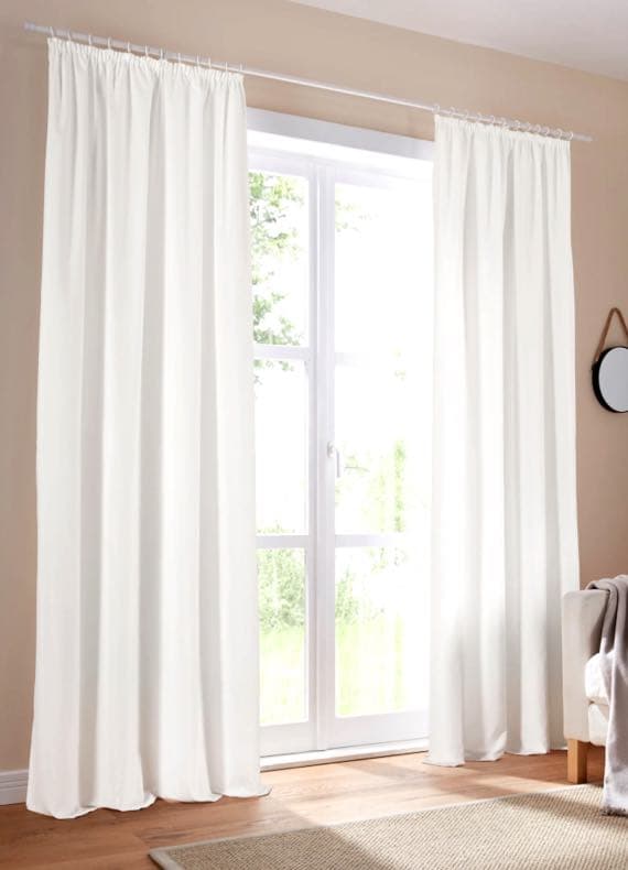 Weiße Vorhänge an einem großen Fenster in einem modernen Wohnzimmer.