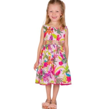 Mädchen im bunt gemusterten Sommerkleid mit Blumen und Blättern, steht frontal und trägt Sandalen