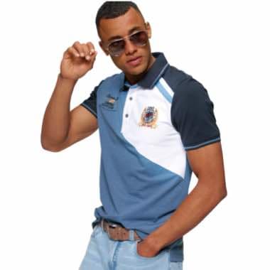 Mann in kurzärmligem Poloshirt mit Farbblöcken und Logo steht lässig mit einer Hand an der Hüfte