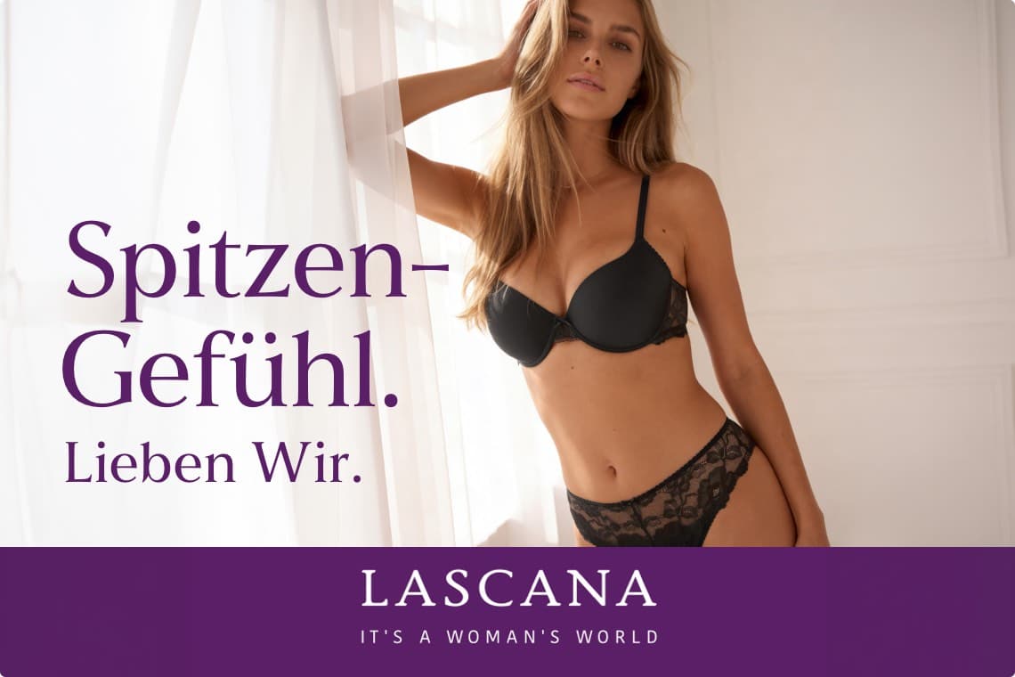 Spitzen-Gefühl. Lieben wir. LASCANA – Frau in schwarzem BH und Slip steht am Fenster und blickt in die Kamera