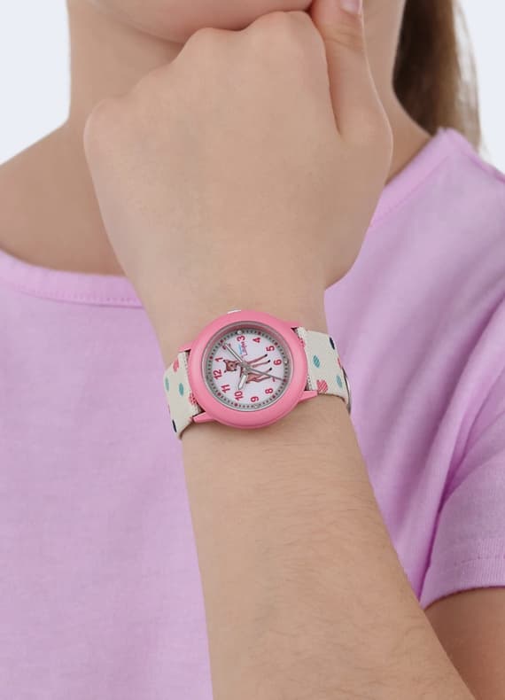 Kinderarm mit bunter Armbanduhr, rosa Rand und Ziffern, getragen zu einem hellrosa T-Shirt
